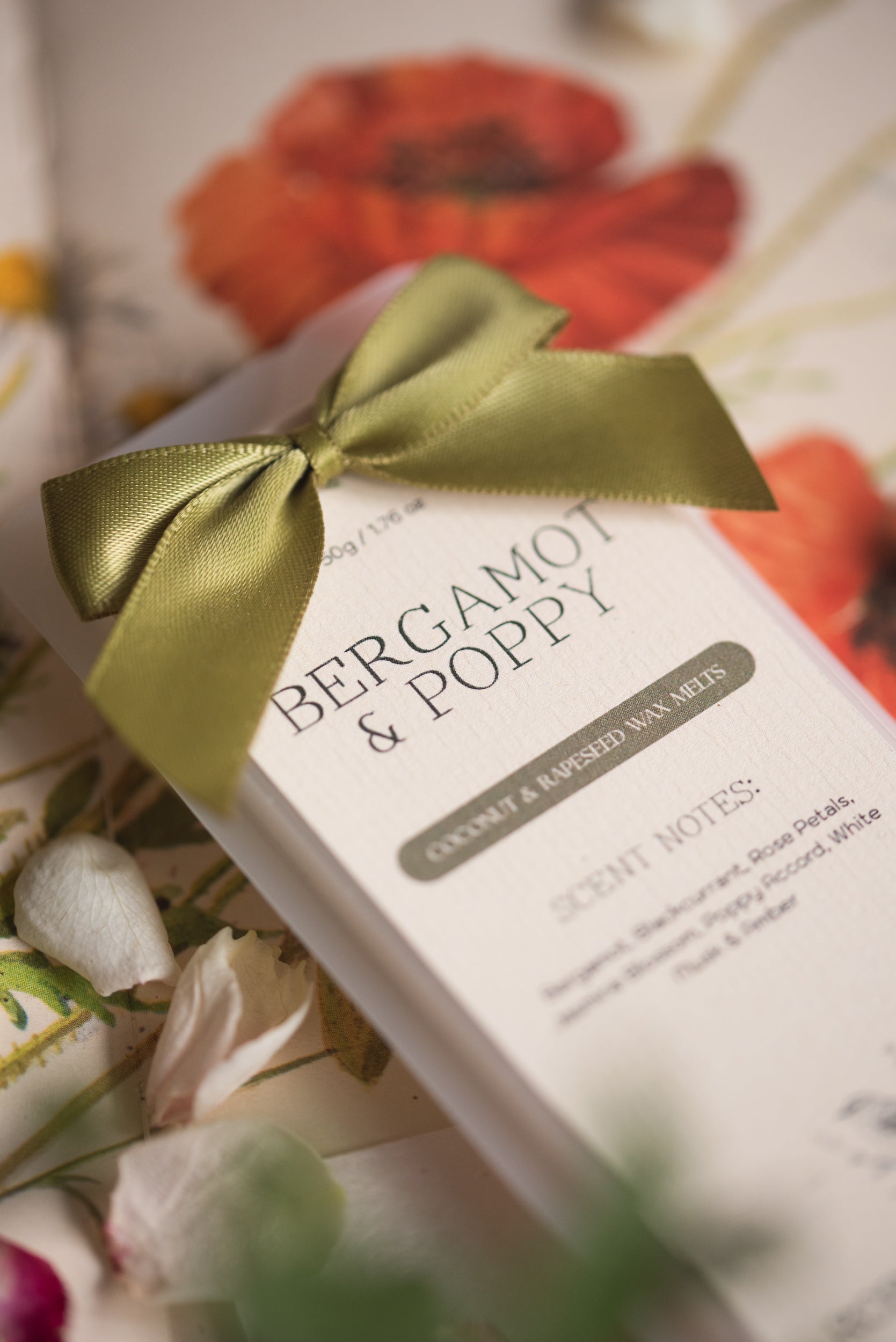 Bergamot & Poppy wax bar with a green ribbon on a floral background