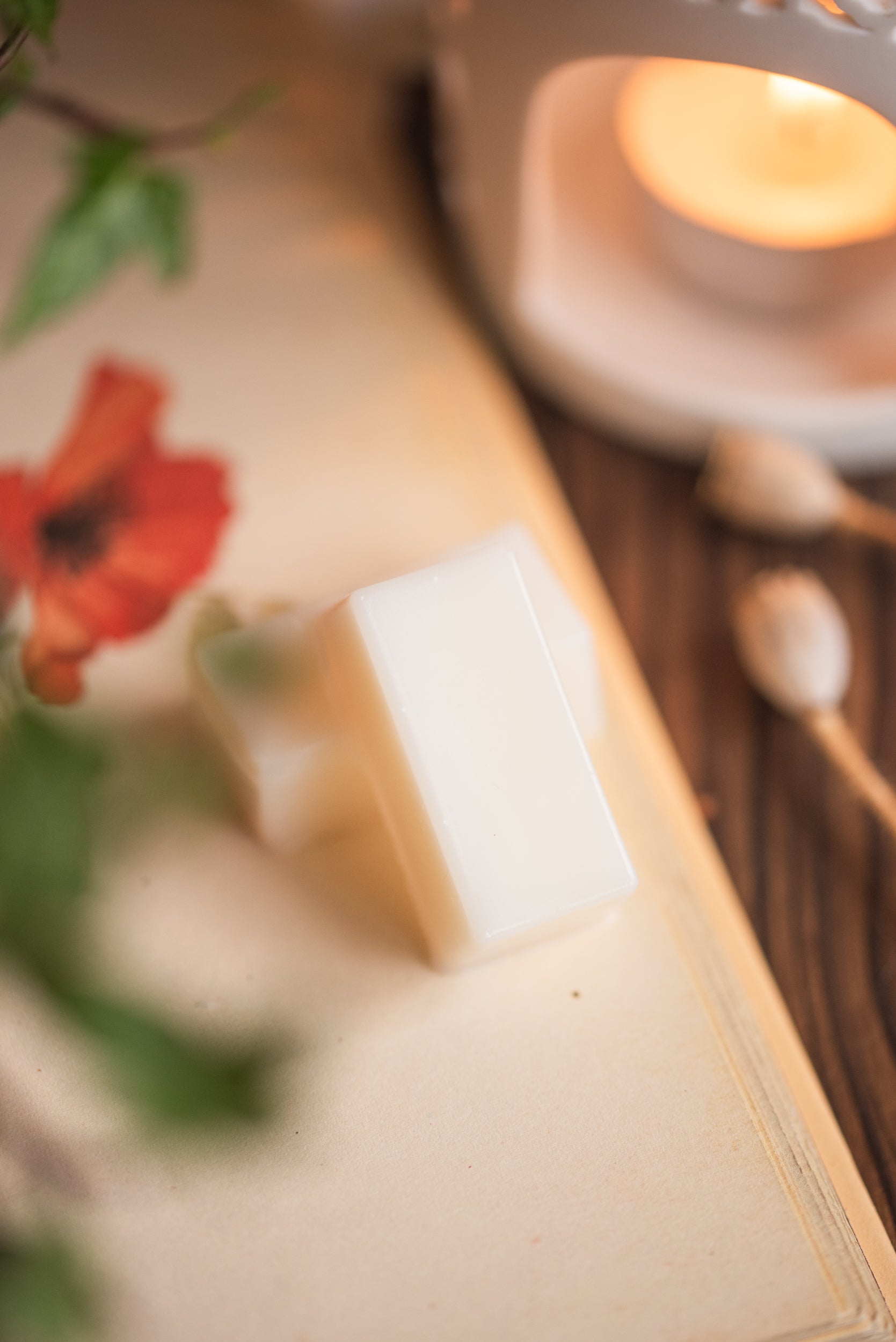 Close-up of a wax melt cube with a tea-light  in the background
