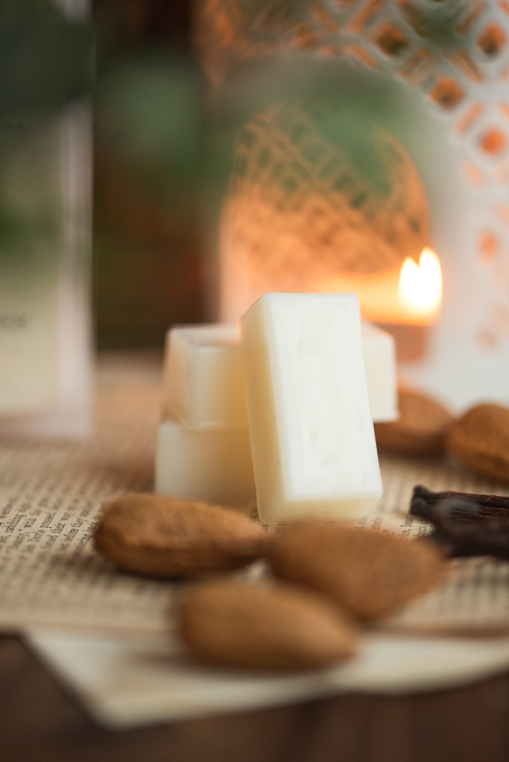 Rectangular wax melts and almonds on a textured surface with a blurred background
